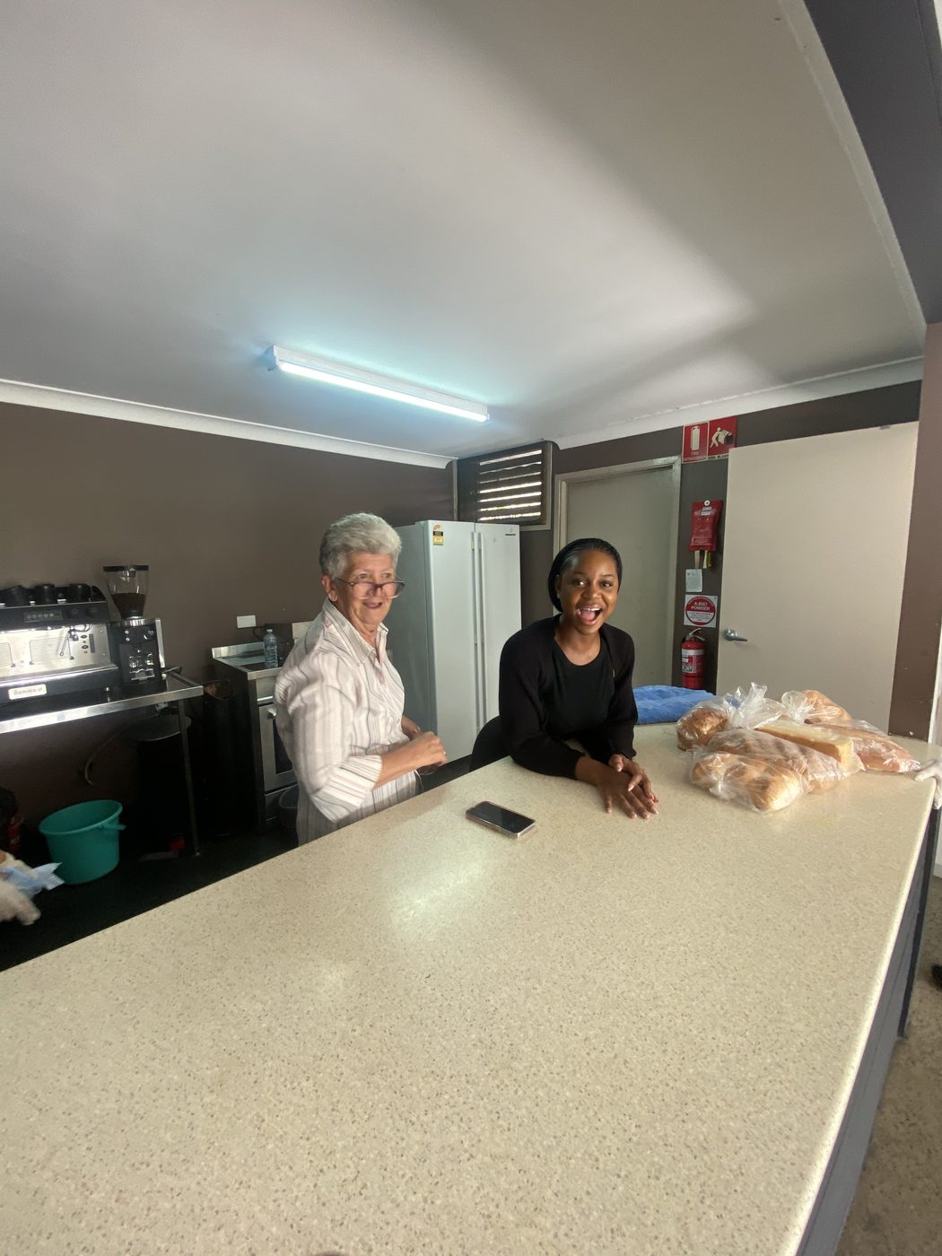 Staff sharing a laugh behind the counter of the on-site cafe