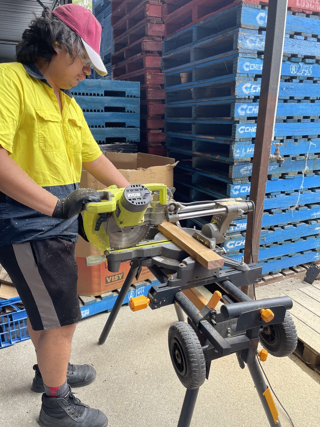 A participant using a mitre saw as part of hands-on maintenance training